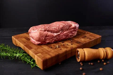 Raw meat. Raw beef steak on a cutting board with rosemary and spices. Foto stock