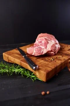 Raw meat. Raw beef steak on a cutting board with rosemary and spices. Stock Photos