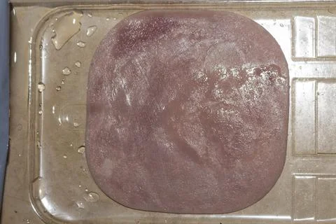 Raw meat slab on baking sheet prepared for cooking in kitchen Фото