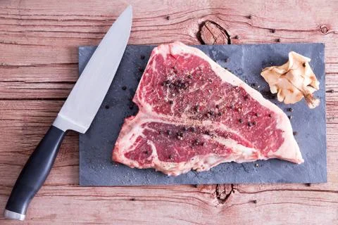 Raw Meat on Table with Pepper, Shiitake and Knife Foto stock