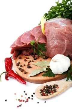 Raw meat, vegetables and spices on a wooden cutting board isolated on white b Stockfoto's