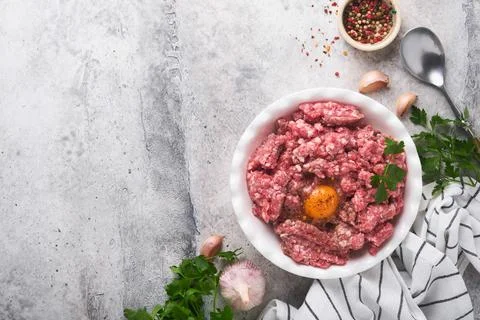 Raw minced meat. Ground meat beef, pork or lamb spices, herbs and eggs on whi Stock Photos