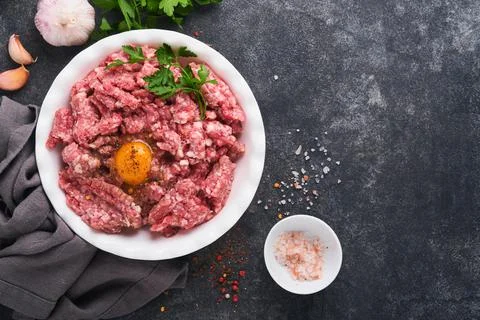 Raw minced meat. Ground meat beef, pork or lamb spices, herbs and eggs on whi Stock Photos