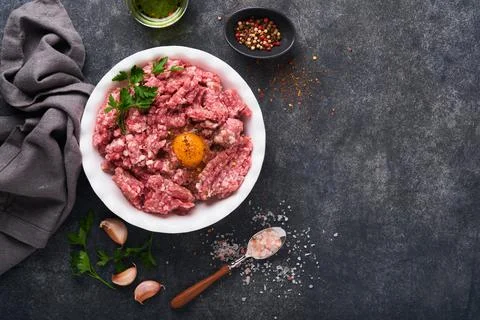 Raw minced meat. Ground meat beef, pork or lamb spices, herbs and eggs on whi Stock Photos