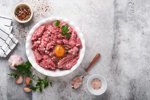 Raw minced meat. Ground meat beef, pork or lamb spices, herbs and eggs on whi Stock Photos