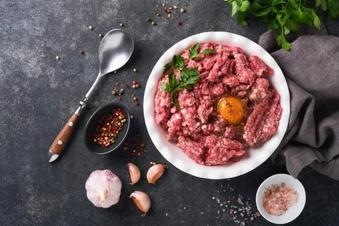 Raw minced meat. Ground meat beef, pork or lamb spices, herbs and eggs on whi Stock Photos