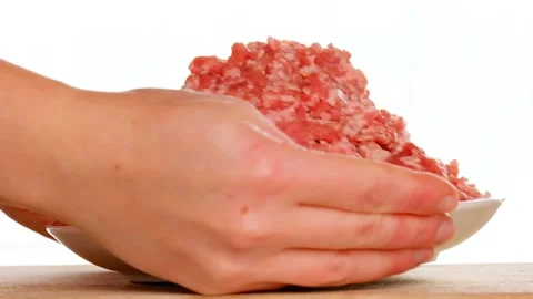 Raw minced pork in a white ceramic cup, hands are taken from the table Stock Footage 192315708