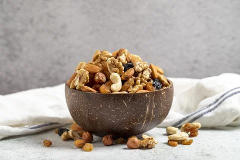 Raw mixed nuts on gray background. Walnuts, almonds, hazelnuts and raisins in Stock Photos