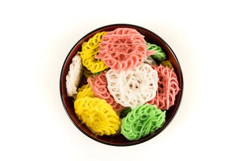 Raw multicolored tapioca crackers in an orange bowl top down isolated over wh Stock Photos