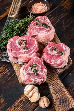 Raw mutton lamb neck meat on a butcher board with cleaver. Dark wooden Stock Photos