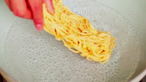 Raw noodles being boiled in hot water Stock Footage 329830295