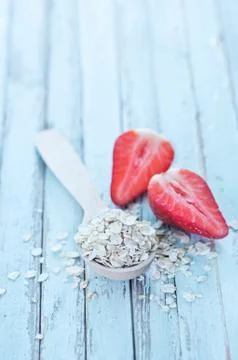 Raw oat flakes in spoon on a table Stock Photos
