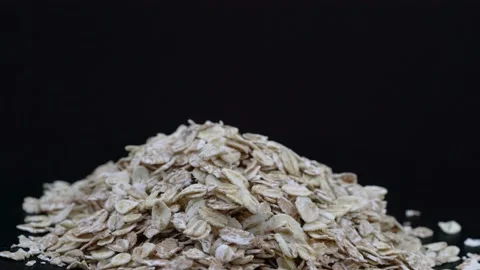 Raw oatmeal on a black background Stock Footage 150874338