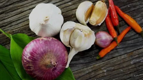 Raw onion garlic and red chilies on wooden surface Stock Footage 333809375