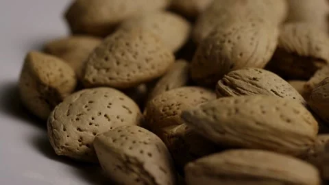 Raw organic almonds in shells rotating on white Stock Footage 328143249
