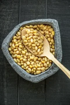 Raw organic pine nuts in a grey asymmetrical bowl. Stock Photos