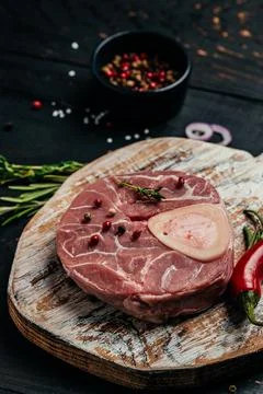 Raw Ossobuko steak marble meat with herbs and spices on dark background. ve.. Stock Photos