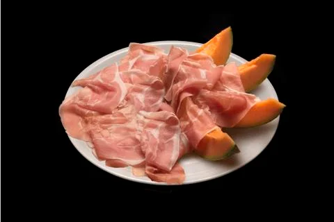 Raw parma ham with melon slices Stock Photos
