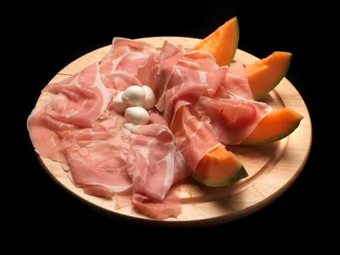 Raw parma ham with melon slices Stock Photos