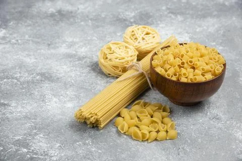Raw pasta and spaghetti varieties on marble background Stock Photos
