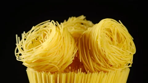 Raw pasta capellini rotating isolated on black background. central composition Stock Footage 131509947