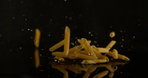 Raw pasta falls at 1000 fps splashing water Video stock 249564083