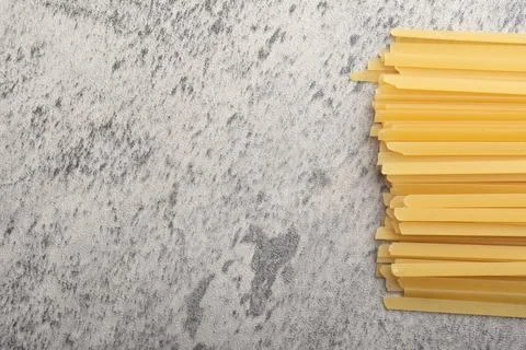 Raw pasta on gray background Stock Photos