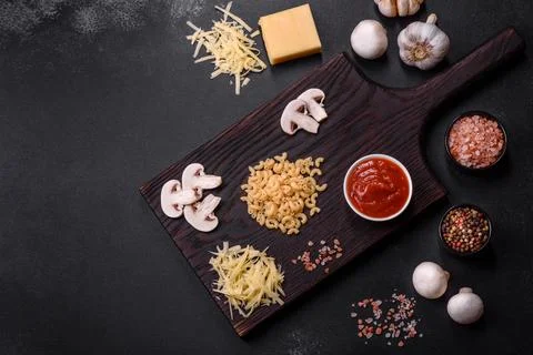 Raw pasta, mushrooms, onions, mince, spices and herbs to make a delicious pas Stock Photos