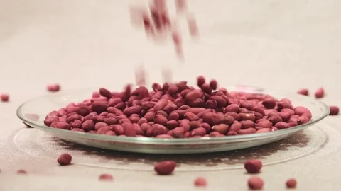 Raw peanuts falling down into glass bowl Stock Footage 72117962