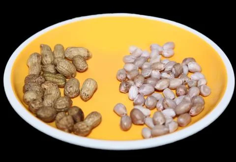 Raw peanuts top view isolated on yellow plate at black background Stock Photos