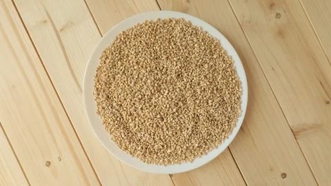 Raw pearl barley rotating on a white plate Видео 336464463