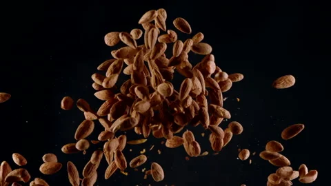 Raw peeled almonds exploding flying up in slow motion, isolated black background Stock Footage 141986726