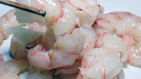 Raw peeled Argentine prawns rotating, sushi chopsticks Vídeo Stock 104957567