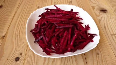 Raw peeled beetroot red rotate in a white plate on a wooden table. Stock Footage 229259794