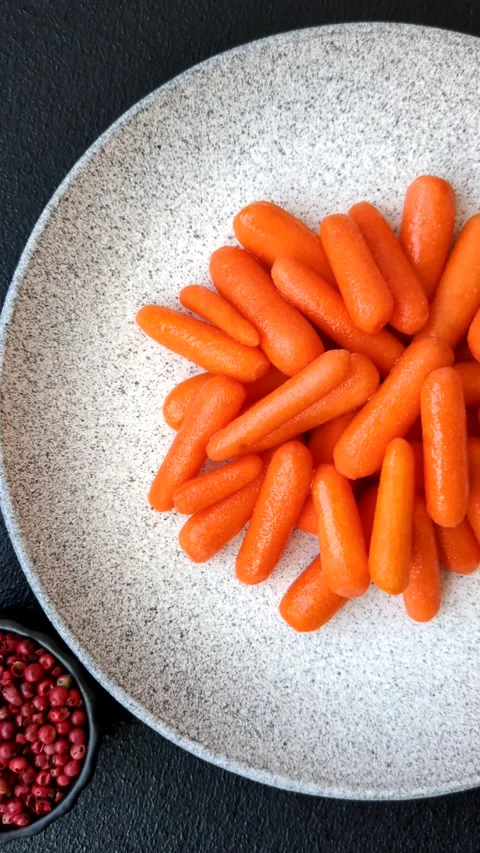 Raw peeled mini baby carrots as an ingredient for preparing a vegetarian food Video stock 302551908