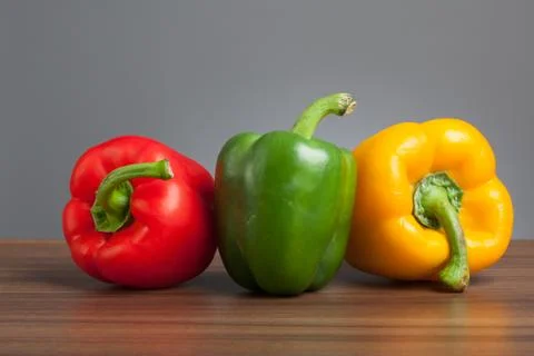 Raw peppers, multiple colors, on table Stock Photos