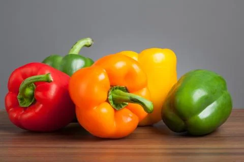 Raw peppers, multiple colors, on table Stock Photos