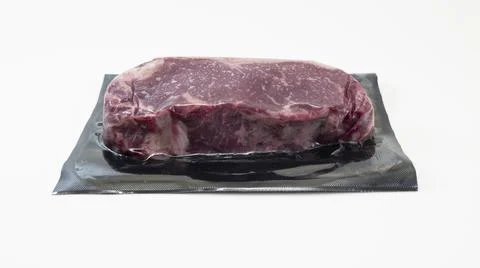 Raw piece of beef for steak in vacuum packaging isolated on white background Stock Photos
