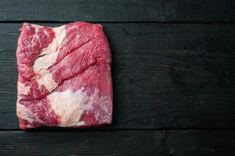 Raw piece of marble beef brisket, on black wooden table background, top view  Stock Photos