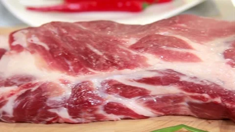 Raw piece of pork meat on board Stock Footage 333874428