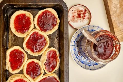 Raw pies with currant jam in baking dish on white table Stock Photos