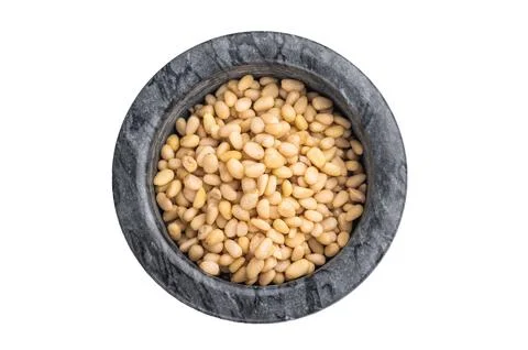 Raw pine nuts in a dark stone bowl on a clean white background creating a b.. Stock Photos