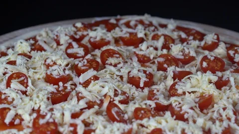 Raw pizza with cherry tomatoes and cheese background, rotating, close up, macro Stock Footage 95162712