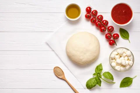 Raw pizza dough with baking ingredients: dough, mozzarella, tomatoes sauce Stock Photos