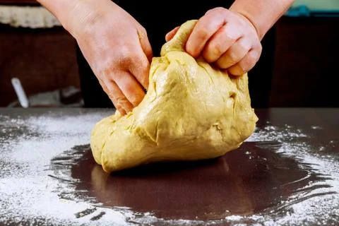 Raw pizza dough in hands of chef. Stock Photos