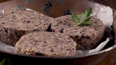 Raw plant-based bean burger patties in a bowl with parchment paper and a pa.. Stock Photos