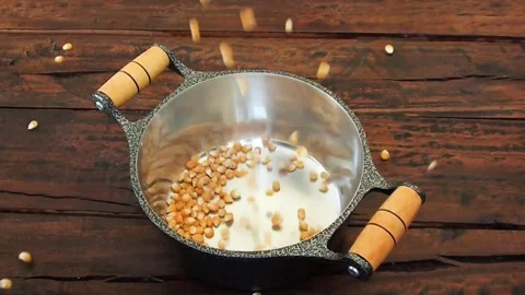 Raw popcorn kernels falling into the pan Stock Footage 251352926