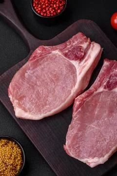 Raw pork on the bone or rib sliced with salt, spices and herbs Stock Photos