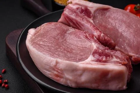 Raw pork on the bone or rib sliced with salt, spices and herbs Foto stock