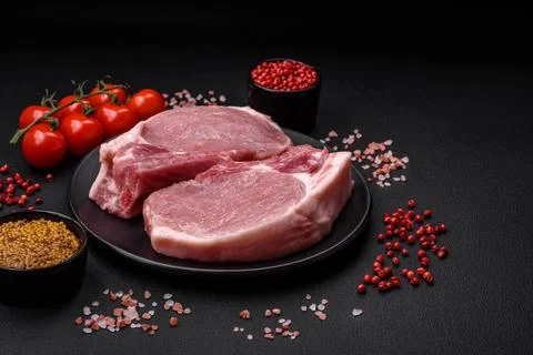 Raw pork on the bone or rib sliced with salt, spices and herbs Stock Photos